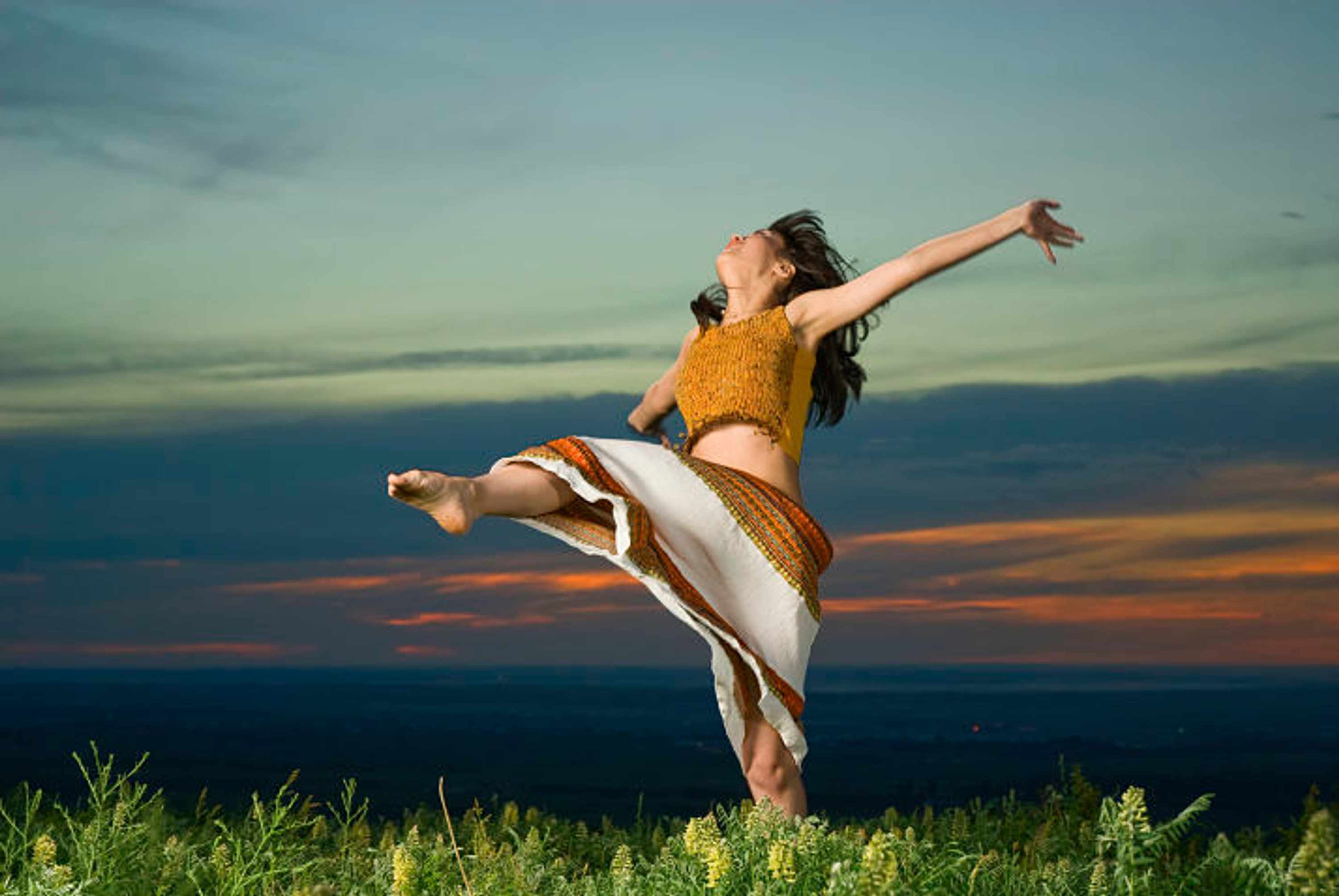 Young beautiful asian woman dancing at sunset, note there is some motion blur